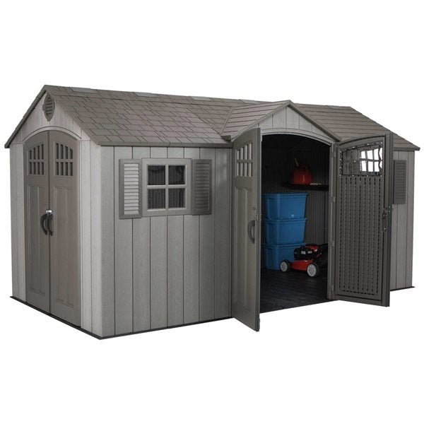 A gray Lifetime 15′ x 8′ Shed (Side Entry) with double doors, one open to show stacked blue bins, a red gas can, and a small red lawnmower inside. The shed has a shingled roof and a side window.